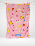 Serviette de plage enfant Kima Rainbow Pink, rose, arcs-en-ciel et fleurs, à plat - Ô Cabanon La Ciotat