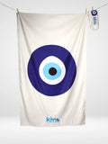 Serviette de plage Kima Œil Grec, blanc, œil grec bleu, à plat - Ô Cabanon La Ciotat